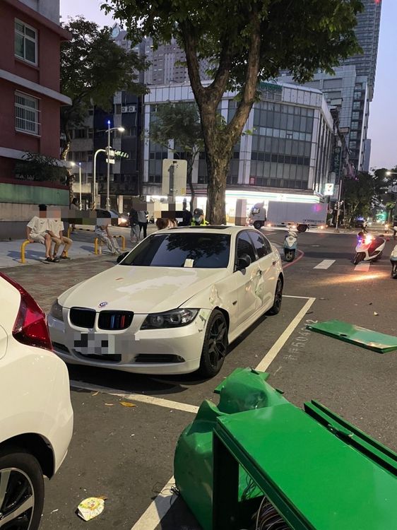 號誌箱被吳男的汽車撞飛，砸到一輛停在路邊的白色BMW。讀者提供