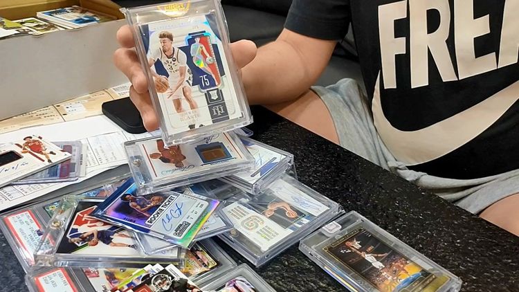 彭先生展示自己收藏的「LOGOMAN」球員卡。鮮明攝