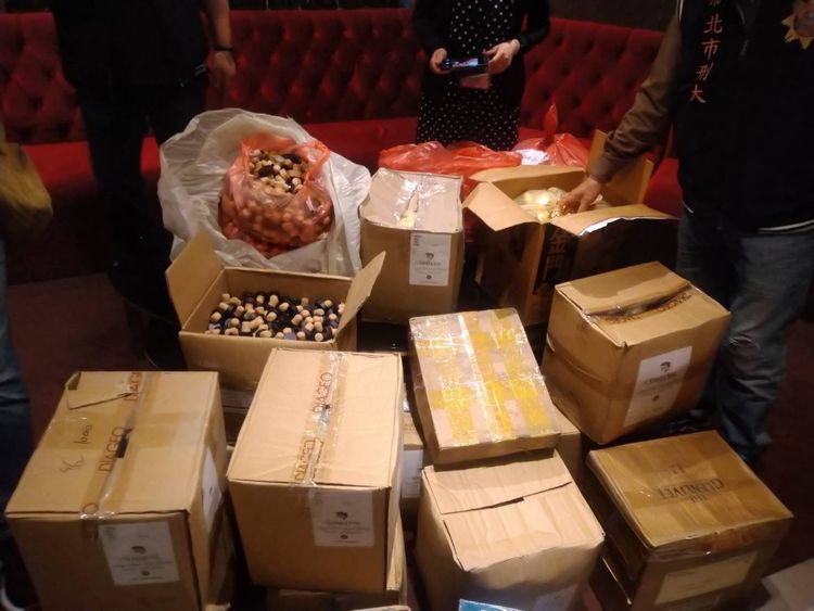 警方當初查獲的假酒，擺滿在地上。翻攝畫面