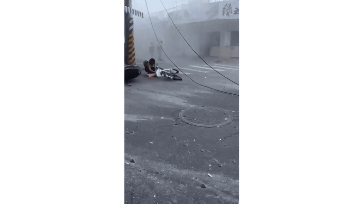 強震發生後，騎士嚇得摔倒，機車也倒在路旁。翻攝畫面