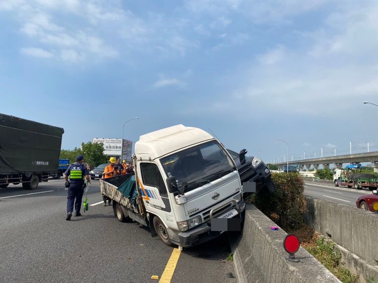 休旅車和小貨車衝上分隔島幾乎相疊。讀者提供