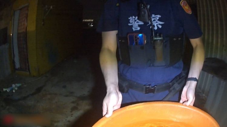 警方端著水桶與隔壁吳姓屋主一同滅火。翻攝畫面