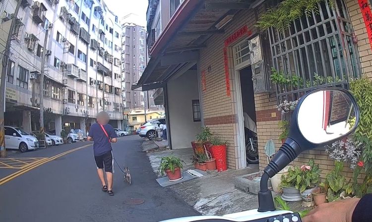 員警騎車在後方護送男童牽著狗回家。讀者提供