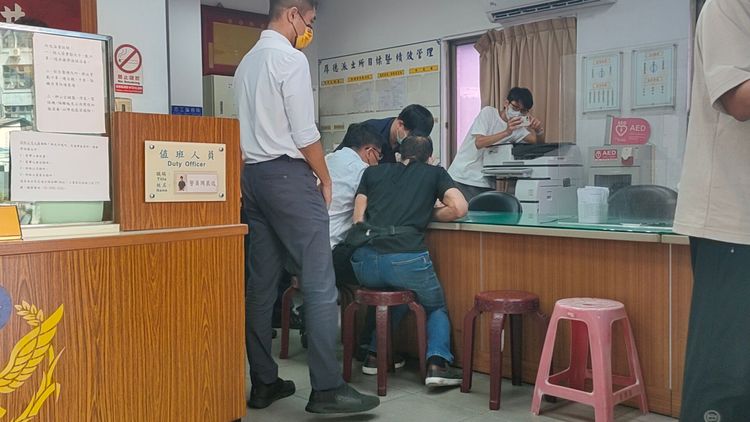 黃男(黑衣者)到派出所領取通知書。黃子騰攝