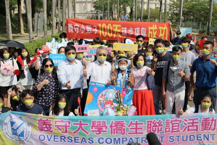 港生梁凱熙千里走全台，第100天走回母校義守大學，師長與學弟妹們在校門口列隊歡迎。義守大學提供
