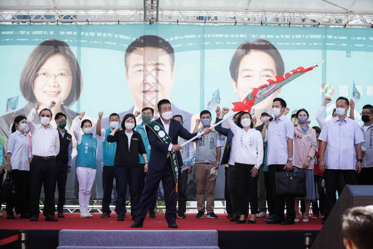 民進黨苗栗縣長參選人徐定禎，在舞台上揮舞旗幟，象徵旗開得勝。徐定禎競總提供
