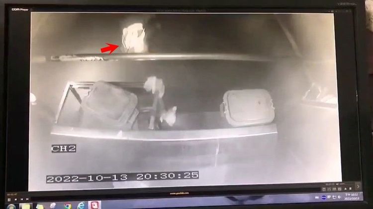 清潔隊員摔下垃圾車，跌落在路面（箭頭），此時垃圾車仍在行駛。翻攝記者爆料網