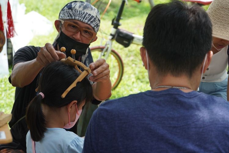 攤商業者幫手作完民眾戴上手作頭飾。屏科大提供