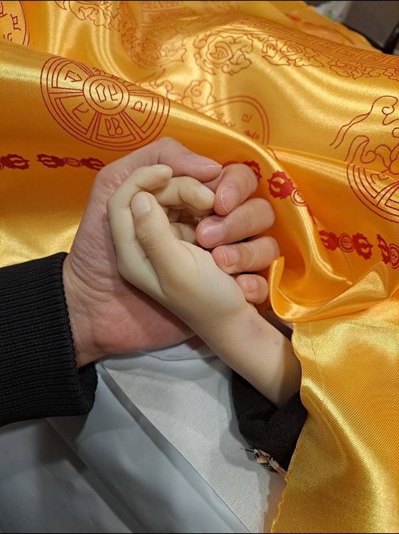 小捷父親緊握小捷冰冷的手不捨祂離開。家屬提供