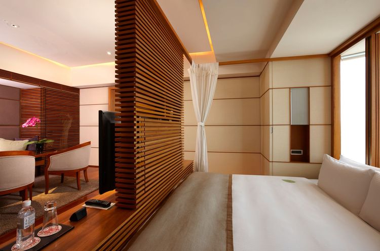 沐蘭套房有倚著落地窗的大床引入陽光與綠意，木質的地板與隔柵也充滿南國風情。晶華酒店提供