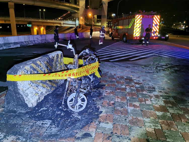 燃燒的機車由消防人員滅火。陸運鋒攝