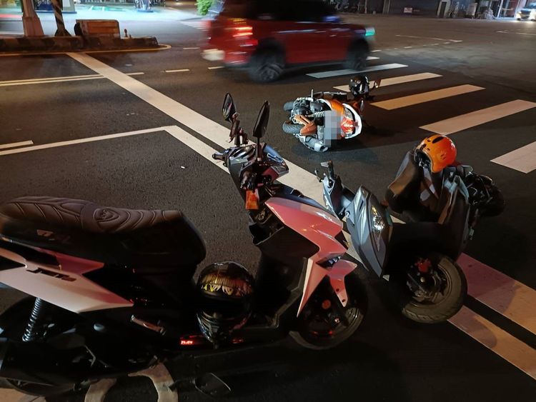 在路口停等紅燈的機車被撞倒。讀者提供