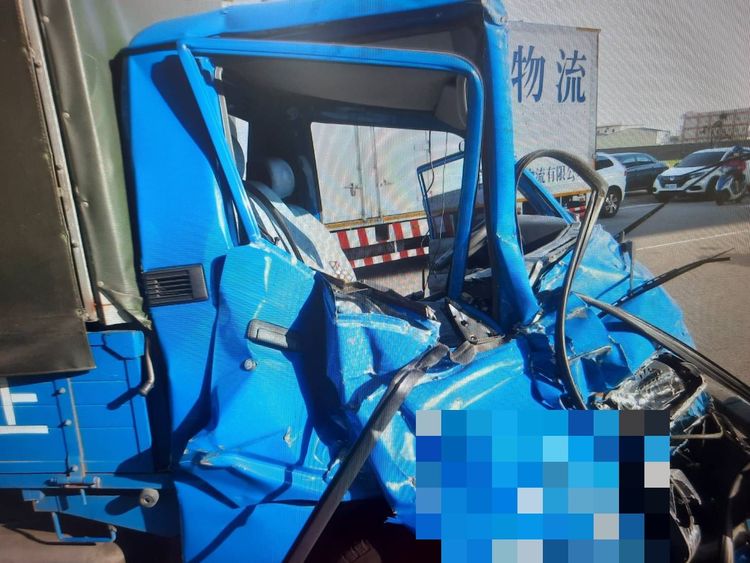 肇事小貨車車頭嚴重扭曲變形，駕駛受困車內傷重被救出送醫。讀者提供
