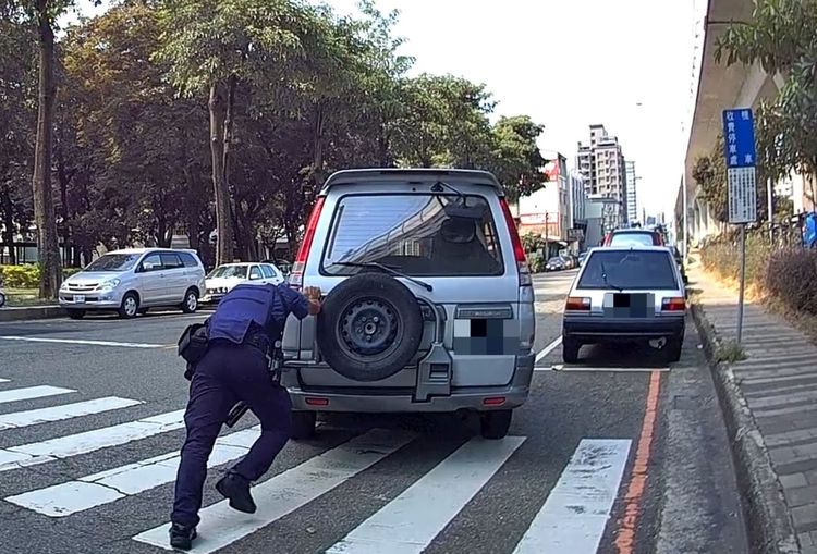 女警林俐伶與巡佐賴彥余聯合使出洪荒之力推車，協助車主排除窘境。警方提供