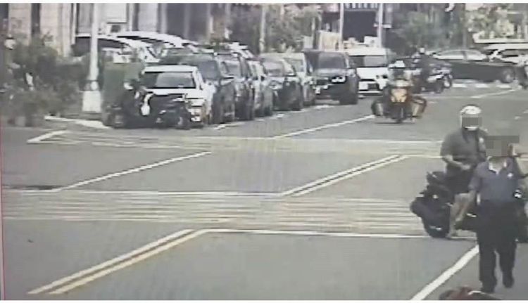 汽車駕駛林姓男子走向倒地的陳姓女騎士，要將她拉上車，引來路過民眾關心。讀者提供
