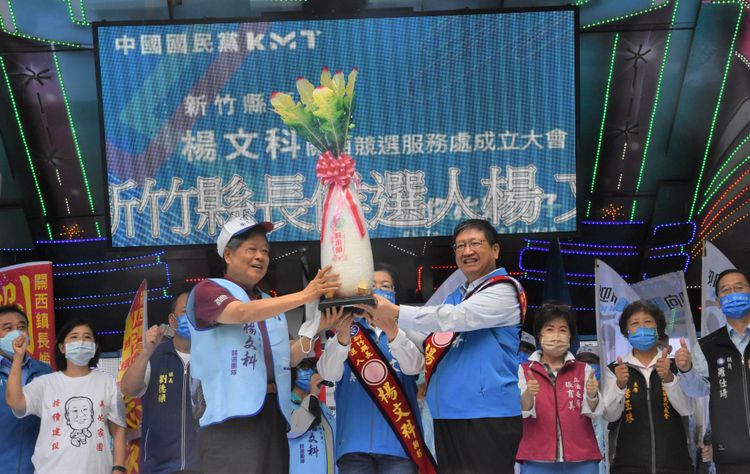 楊文科競選總部主任委員、前縣長范振宗（前左），贈送新竹縣長候選人楊文科（前右）好彩頭。楊文科競辦提供