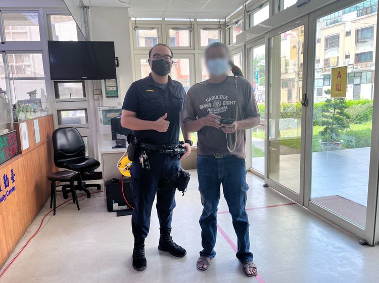 員警將「球球」交還飼主柯姓男子。讀者提供