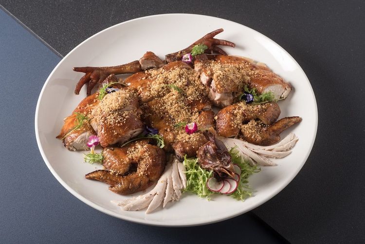 「香蒜脆皮走山雞襯涼拌山野鮮蔬」選用放山玉米雞，運用雲林香蒜與秘製香料醃製，淋上醋水油炸至外皮薄酥脆、肉質鮮嫩多汁，再搭配清脆爽口不油膩山泉野蔬，成就一道齒頰留香的宴客佳餚。台北六福萬怡酒店提供