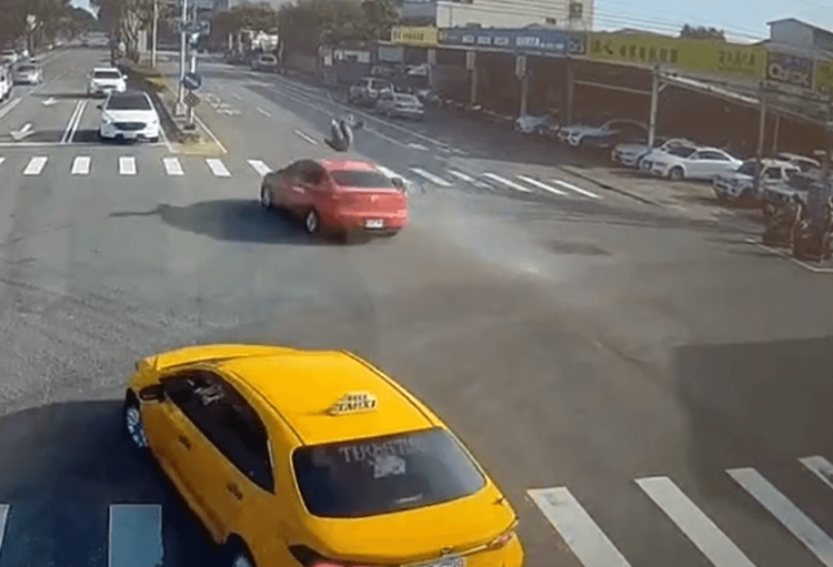 陳女駕駛紅色自小客闖紅燈，將機車騎士撞到騰空。讀者提供