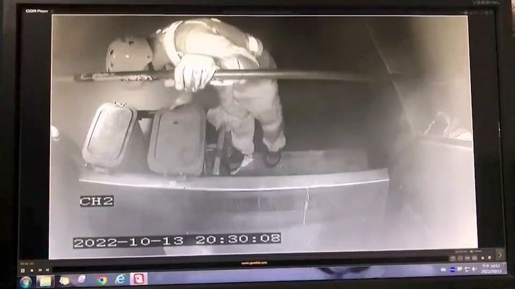 清潔隊員在行駛的垃圾車車斗後方搬運廚餘筒，剛開始還有以一手扶著車子的扶手。翻攝記者爆料網