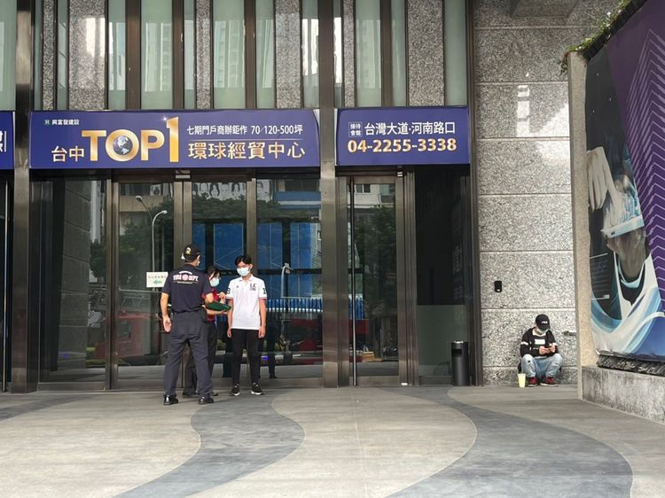 消防隊員在大樓門口進行消防安全宣導。周庭慶攝