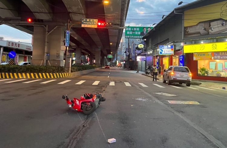 謝女騎乘的機車倒地，蔡男的休旅車則停在一旁等待警方採證。三重警分局提供