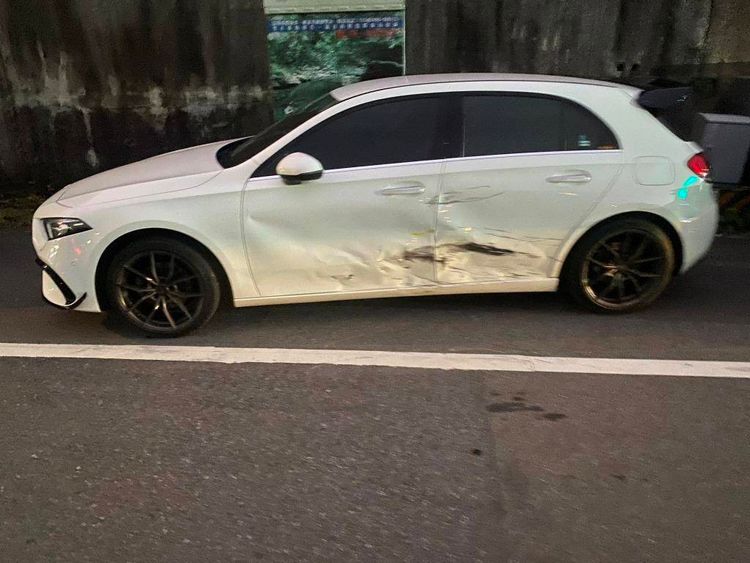 停放路旁的賓士車，被撞後車身嚴重凹陷。讀者提供