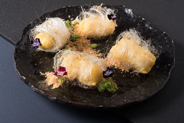 「神仙蟬絲脆鮮奶」為發想自廣東順德傳統名點，外金黃、內潔白，酥脆的外皮包裹著濃郁的鮮奶，再纏繞著白色糖絲，撒上金箔成為夢境中神仙級高檔甜品。台北六福萬怡酒店提供