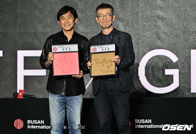 梁朝偉（左）拿著手印與影展主席許文永合影。翻攝OSEN