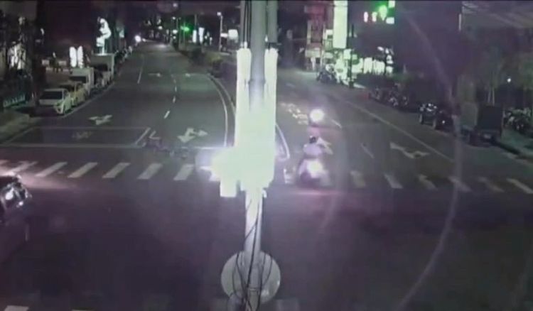 監視器拍到男子機車停路中央，下車到對向撿拾蔬果。翻攝畫面