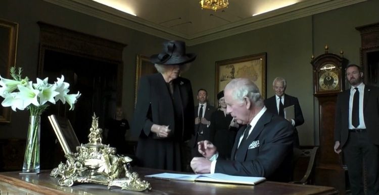 查理三世把筆交給王后卡蜜拉的時候，發現中指沾染漏出的筆墨。路透社影片截圖